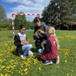 Vonkajšie aktivity detí - pletenie venčekov z púpavy.